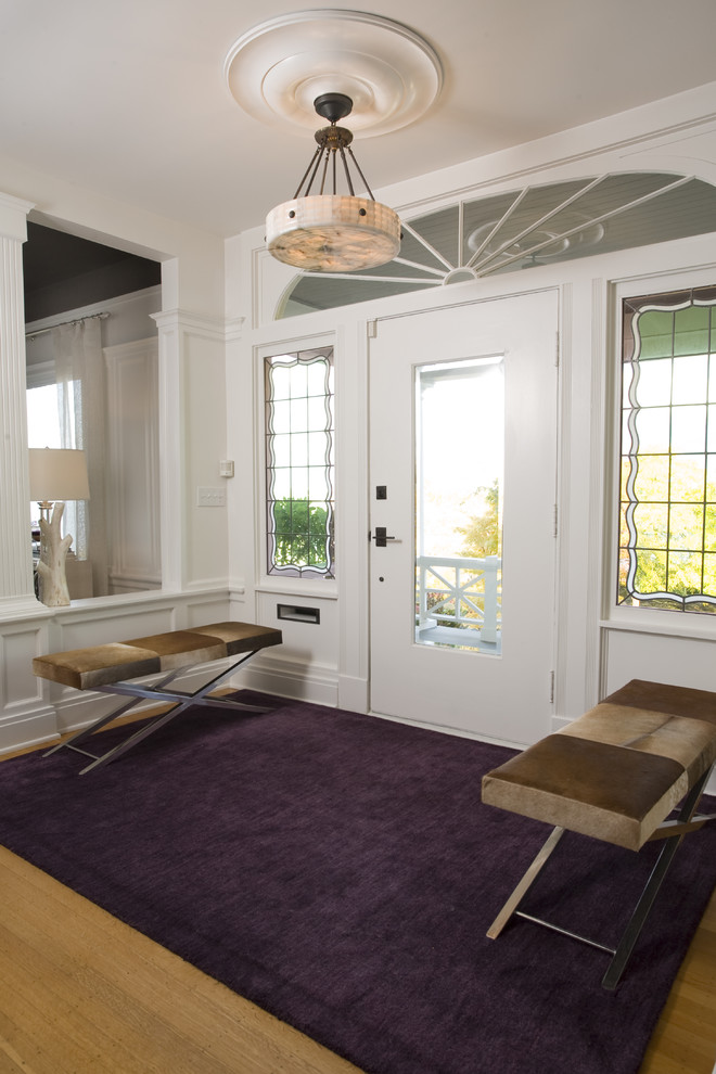 This is an example of a transitional entryway in Seattle with white walls and medium hardwood floors.