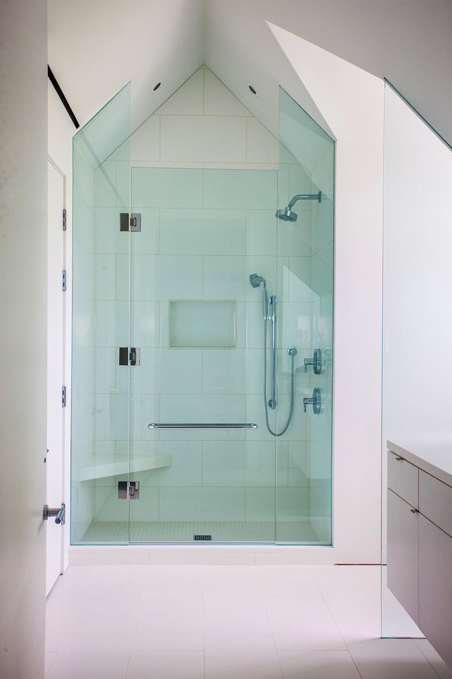 Photo of a contemporary bathroom in Miami with flat-panel cabinets, white cabinets, an alcove shower and white tile.