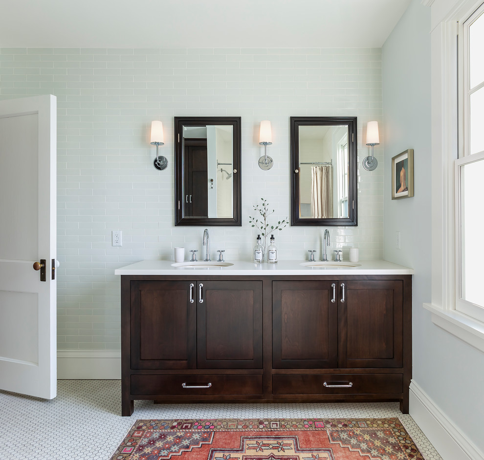 Mid-sized traditional master bathroom in Minneapolis with shaker cabinets, dark wood cabinets, porcelain floors, an undermount sink, solid surface benchtops, white floor, white benchtops and subway tile.
