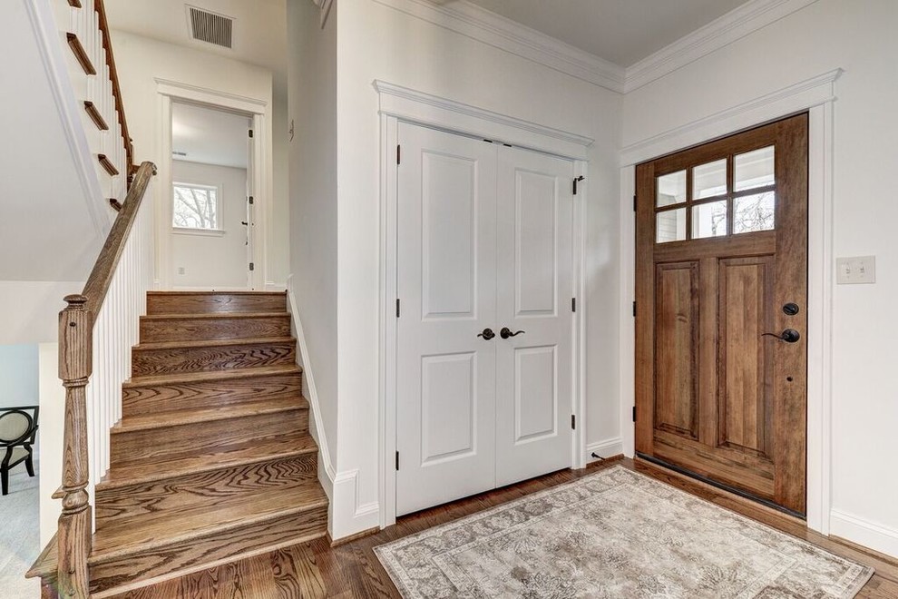 Inspiration for a transitional medium tone wood floor foyer remodel in DC Metro with white walls and a medium wood front door