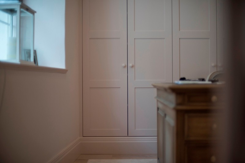 This is an example of a medium sized traditional study with white walls, light hardwood flooring, a freestanding desk and brown floors.