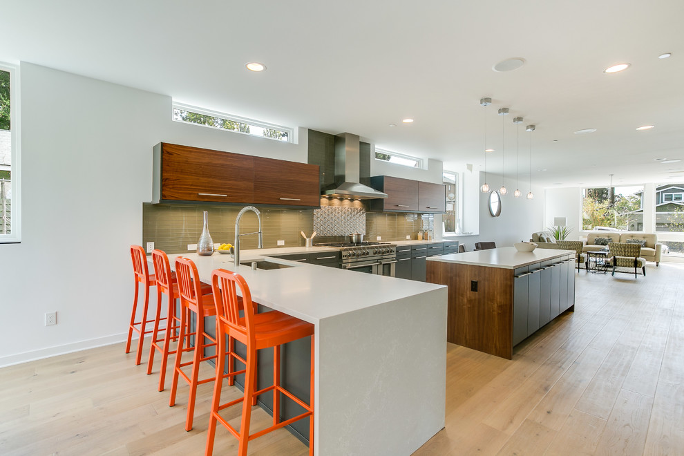 Inspiration for a large contemporary l-shaped open plan kitchen in Seattle with an undermount sink, flat-panel cabinets, dark wood cabinets, green splashback, glass tile splashback, stainless steel appliances, medium hardwood floors, with island, quartz benchtops, beige floor and white benchtop.