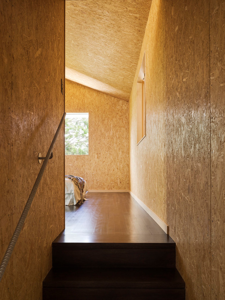 This is an example of a contemporary master bedroom in Brisbane with painted wood floors.