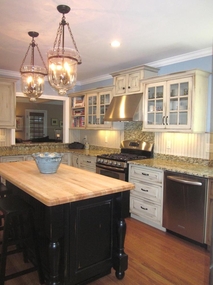 This is an example of a large traditional u-shaped eat-in kitchen in Louisville with granite benchtops, white splashback, stainless steel appliances, light hardwood floors, with island, timber splashback, an undermount sink, raised-panel cabinets and distressed cabinets.