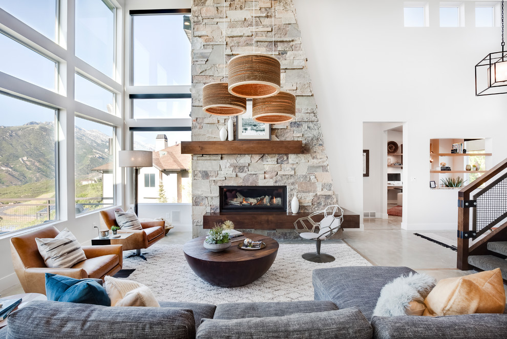 This is an example of a country open concept living room in Salt Lake City with white walls, a ribbon fireplace and grey floor.