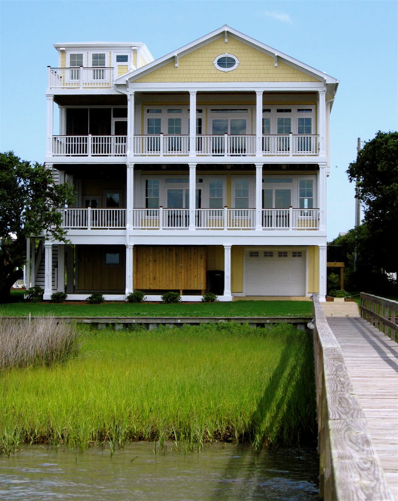 Design ideas for a beach style three-storey yellow exterior in Wilmington.
