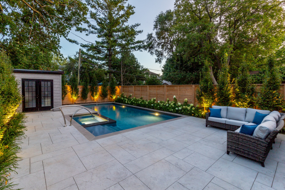 This is an example of a small transitional backyard rectangular pool in Toronto with with a pool and stamped concrete.