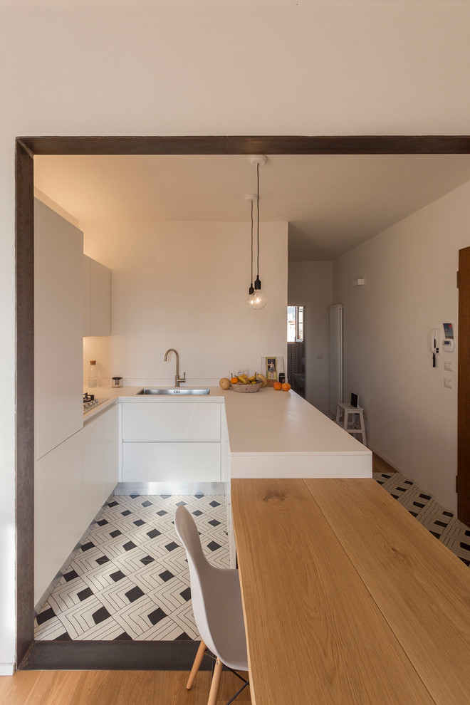 Cucina abitabile?[Foto di cucina abitabile With lavello da incasso, ante lisce, ante bianche, top in superficie solida, pavimento con piastrelle in ceramica and penisola]:[Foto di cucine abitabili With lavello da incasso, ante lisce, ante bianche, top in superficie solida, pavimento con piastrelle in ceramica and penisola]