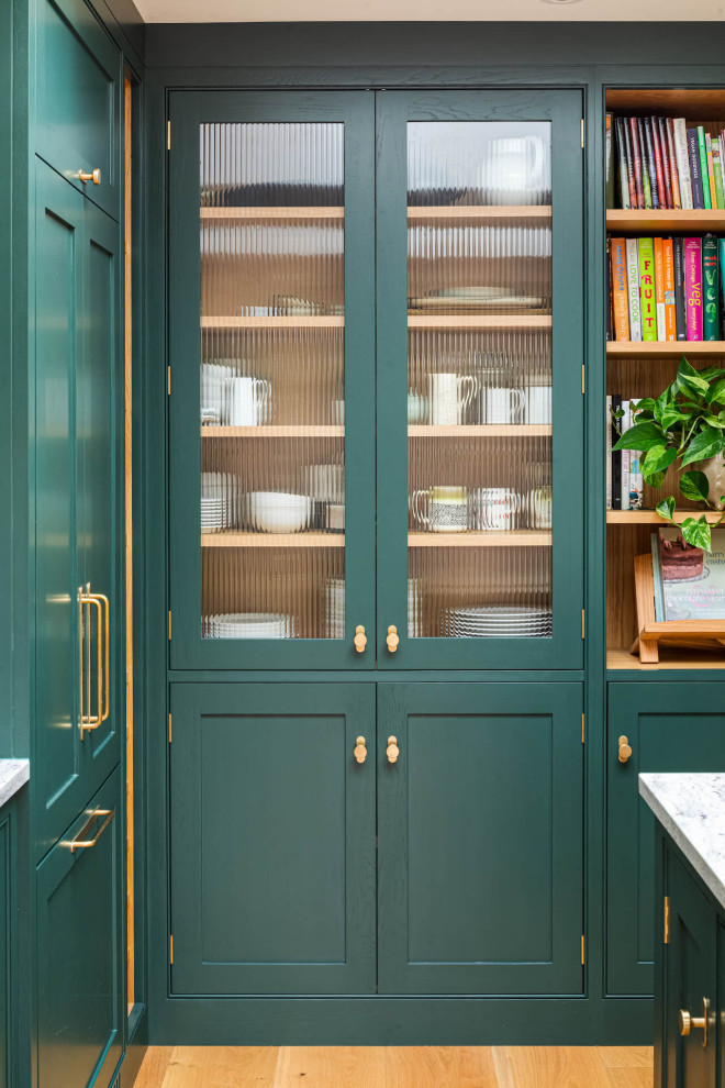 Klassisk inredning av ett stort grå grått kök, med en undermonterad diskho, skåp i shakerstil, gröna skåp, granitbänkskiva, rostfria vitvaror och en köksö