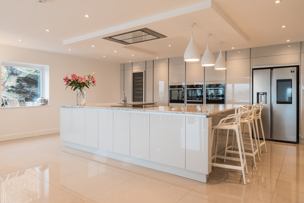 Inspiration for an expansive contemporary u-shaped open plan kitchen in Other with an integrated sink, flat-panel cabinets, grey cabinets, granite benchtops, stainless steel appliances, marble floors, with island, white floor, beige benchtop and recessed.