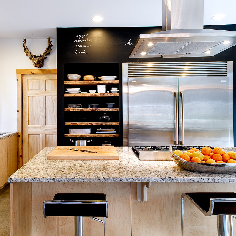 Photo of a mid-sized country eat-in kitchen in Burlington with an undermount sink, flat-panel cabinets, light wood cabinets, recycled glass benchtops, stainless steel appliances, concrete floors, with island and grey floor.