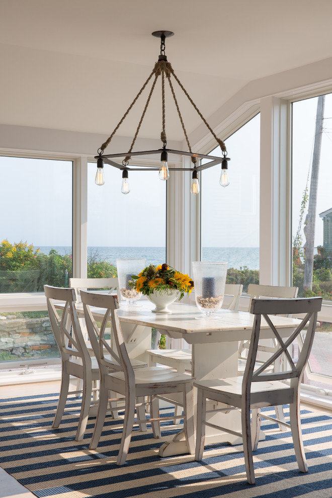 Mid-sized beach style open plan dining in Portland Maine with white walls and light hardwood floors.