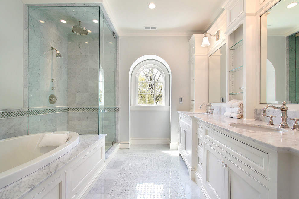 Large transitional master bathroom in Toronto with a drop-in tub, a corner shower, grey walls, an undermount sink, a hinged shower door, shaker cabinets, white cabinets, porcelain floors and marble benchtops.