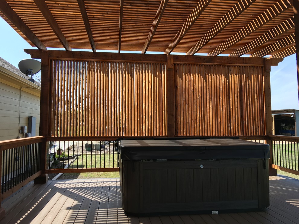 This is an example of a mid-sized traditional backyard deck in Austin with a pergola.