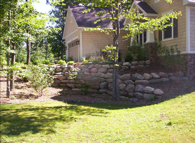Inspiration for a large full sun front yard retaining wall landscape.
