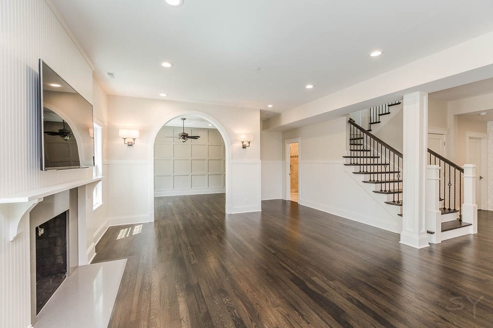 Inspiration for a mid-sized transitional formal enclosed living room in Chicago with beige walls, dark hardwood floors, a standard fireplace, a stone fireplace surround and a wall-mounted tv.