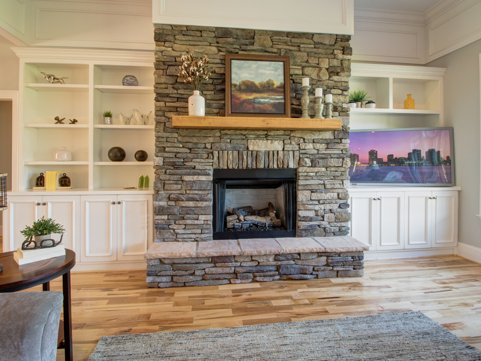 Inspiration for a large transitional open concept family room in Other with grey walls, light hardwood floors, a standard fireplace, a freestanding tv, multi-coloured floor and a stone fireplace surround.