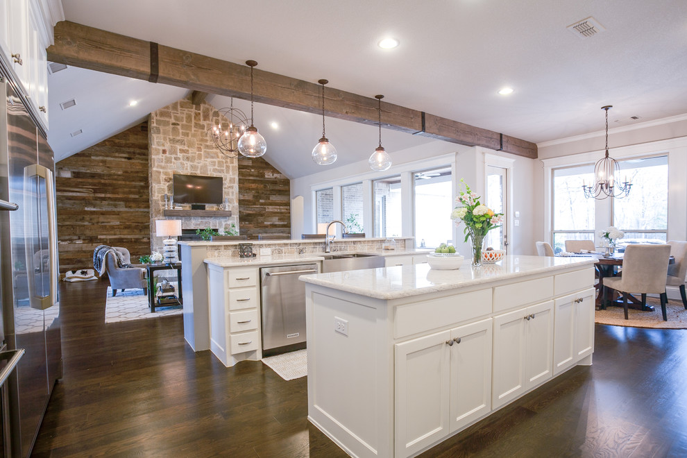 This is an example of a large country u-shaped open plan kitchen in Dallas with shaker cabinets, white cabinets, marble benchtops, grey splashback, stone tile splashback, stainless steel appliances, dark hardwood floors, with island and a farmhouse sink.
