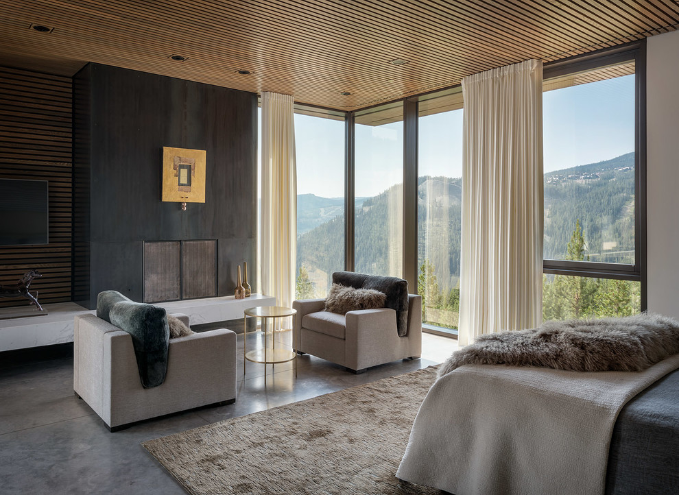 This is an example of a country master bedroom in Seattle with concrete floors, a standard fireplace and grey floor.