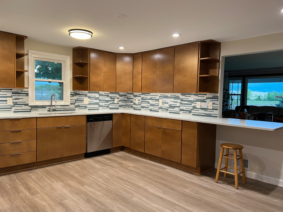 This is an example of a large traditional u-shaped kitchen pantry in Cleveland with flat-panel cabinets, medium wood cabinets and engineered stone countertops.