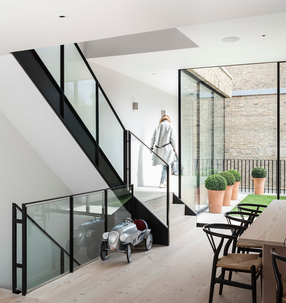 This is an example of a mid-sized modern wood l-shaped staircase in London with wood risers.