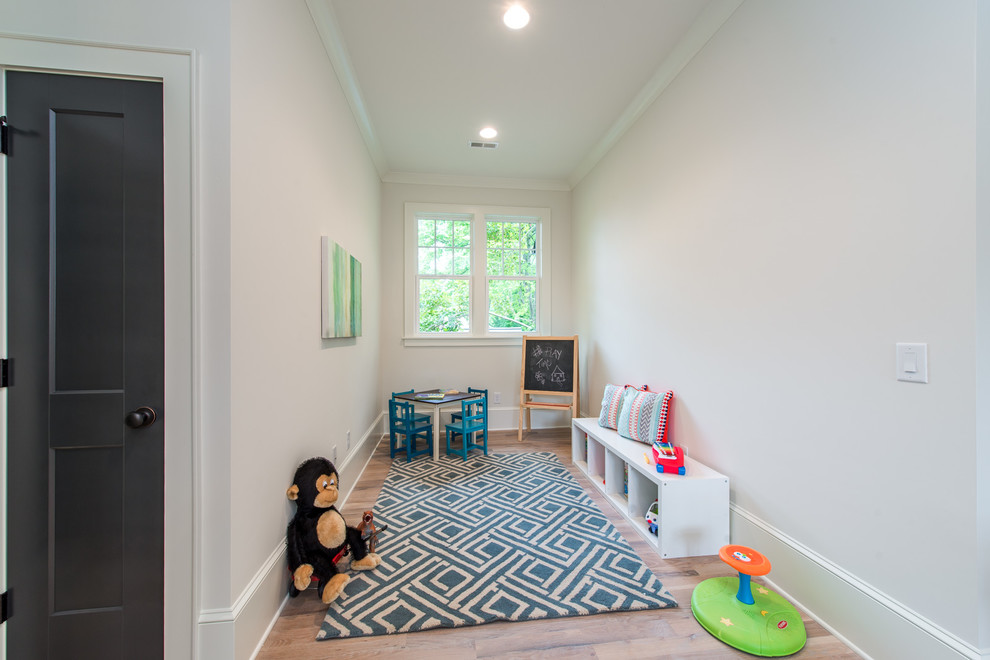 Design ideas for a mid-sized kids' playroom in Charlotte with beige walls, light hardwood floors and beige floor.