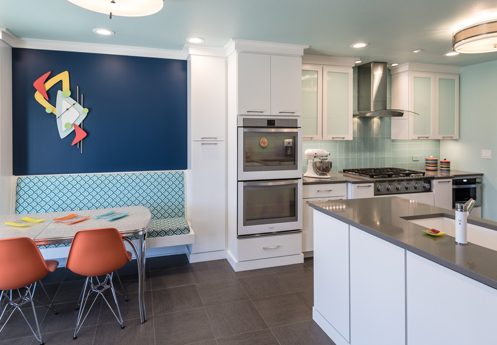 This is an example of a large modern l-shaped eat-in kitchen in St Louis with an undermount sink, flat-panel cabinets, white cabinets, quartz benchtops, blue splashback, glass tile splashback and a peninsula.