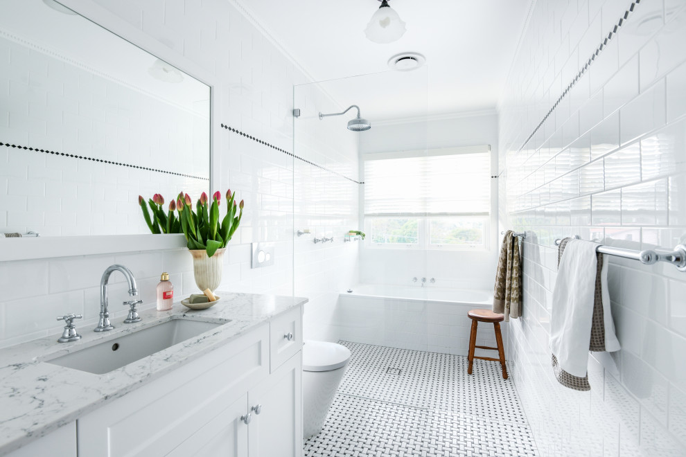 Transitional wet room bathroom in Sydney with shaker cabinets, white cabinets, an alcove tub, white tile, mosaic tile floors, an undermount sink, multi-coloured floor, an open shower, grey benchtops, a single vanity and a built-in vanity.