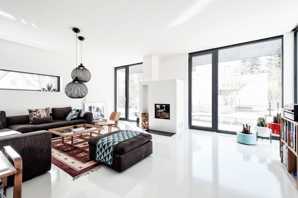 This is an example of an expansive modern enclosed living room in Munich with white walls, a standard fireplace and a plaster fireplace surround.