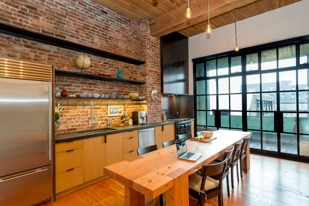 Design ideas for an industrial single-wall eat-in kitchen in Seattle with an undermount sink, flat-panel cabinets, medium wood cabinets, stainless steel appliances and medium hardwood floors.