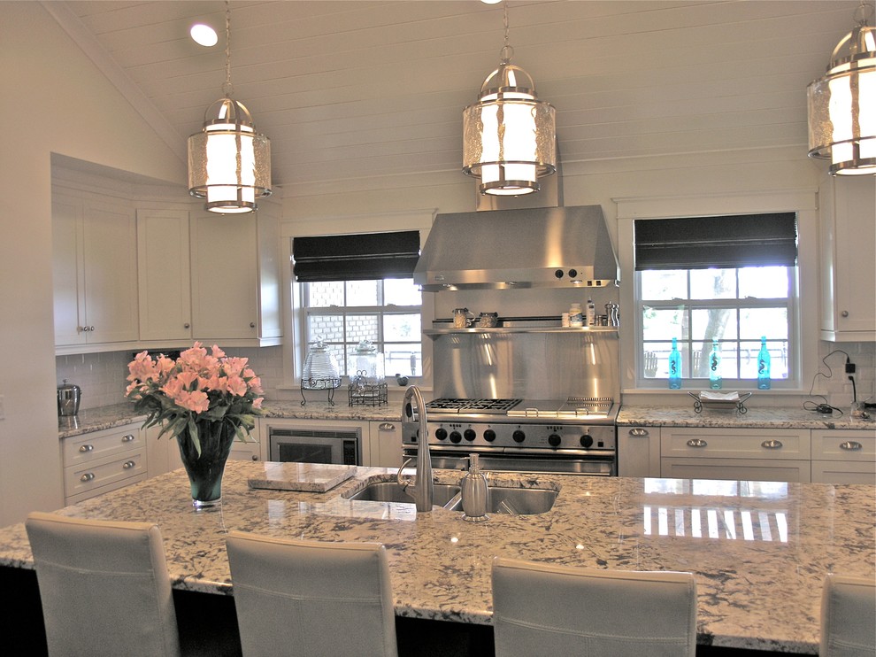 This is an example of a large transitional u-shaped eat-in kitchen in Jacksonville with an undermount sink, shaker cabinets, white cabinets, granite benchtops, white splashback, subway tile splashback, stainless steel appliances and grey floor.