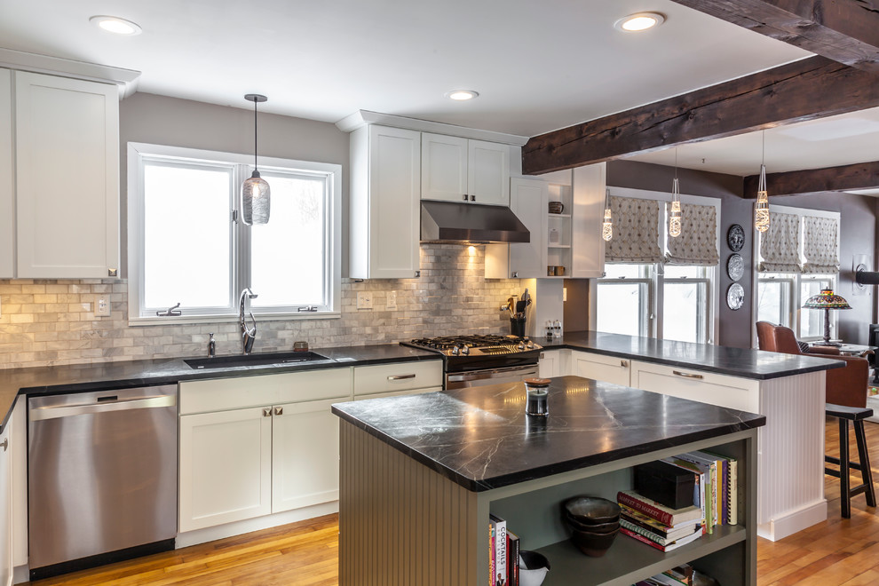 Inspiration for a mid-sized arts and crafts u-shaped eat-in kitchen in Burlington with an undermount sink, shaker cabinets, white cabinets, soapstone benchtops, white splashback, stone tile splashback, stainless steel appliances, light hardwood floors and with island.