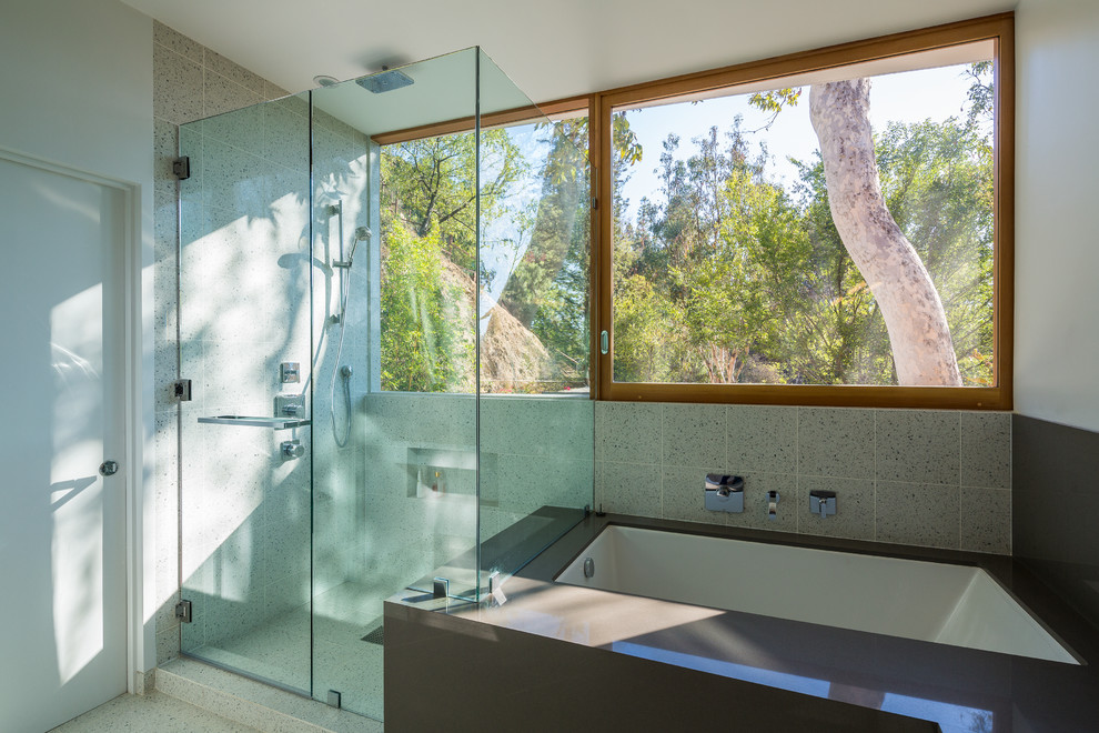 This is an example of a mid-sized contemporary master bathroom in Los Angeles with flat-panel cabinets, white cabinets, an undermount tub, a corner shower, a one-piece toilet, multi-coloured tile, cement tile, white walls, ceramic floors, an undermount sink, quartzite benchtops, grey floor and a hinged shower door.