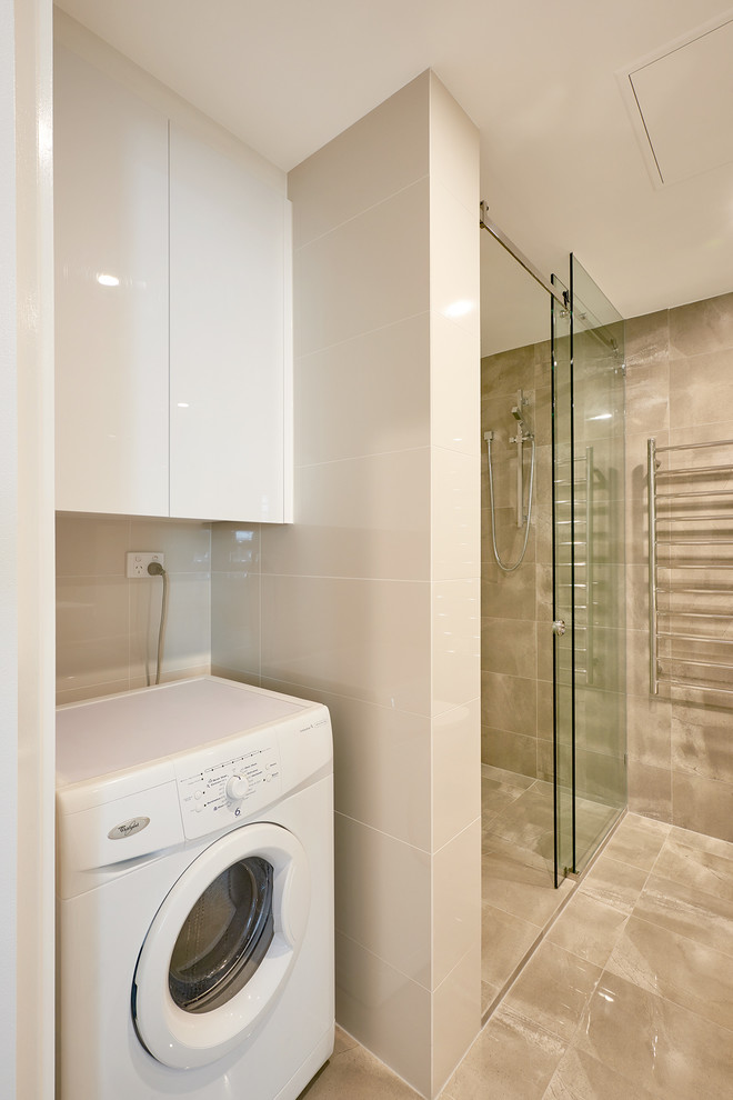 Inspiration for a small master bathroom in Melbourne with white cabinets, a corner shower, a one-piece toilet, brown tile, porcelain tile, beige walls, porcelain floors, solid surface benchtops, brown floor, a hinged shower door, beige benchtops and a laundry.