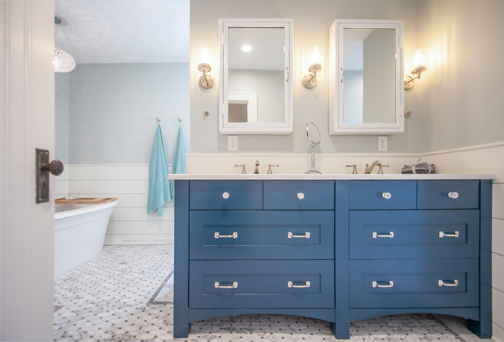 Inspiration for a mid-sized transitional master wet room bathroom in Cedar Rapids with blue cabinets, a freestanding tub, a one-piece toilet, blue walls, multi-coloured floor, a hinged shower door, flat-panel cabinets, marble floors, an undermount sink and quartzite benchtops.