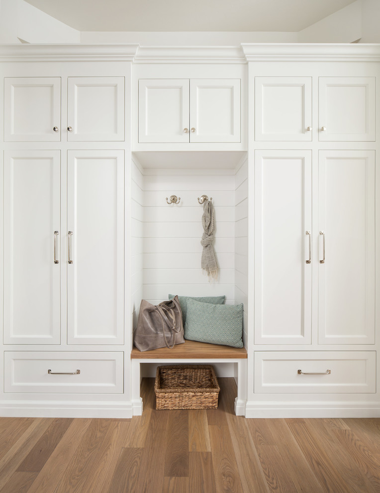 Country mudroom in Salt Lake City with white walls and medium hardwood floors.