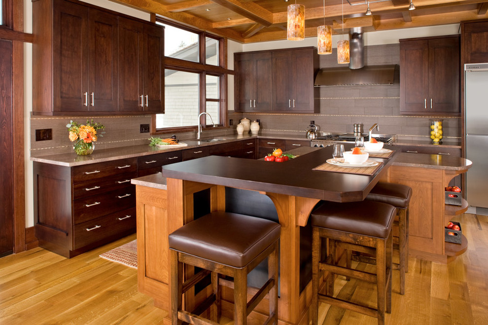 Design ideas for a mid-sized traditional kitchen in Los Angeles with an undermount sink, shaker cabinets, dark wood cabinets, beige splashback, stainless steel appliances, medium hardwood floors and with island.
