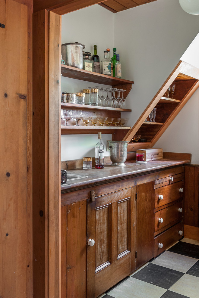 Inspiration for a small traditional single-wall wet bar in Other with a drop-in sink, recessed-panel cabinets, medium wood cabinets, beige splashback, timber splashback, linoleum floors and beige benchtop.