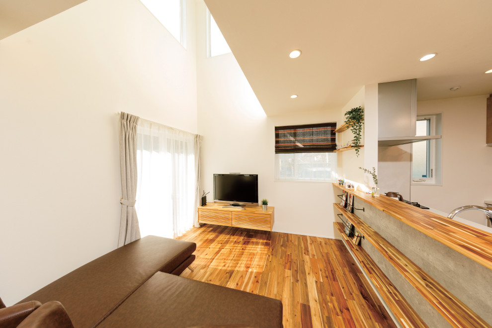 This is an example of a small modern formal open concept living room in Tokyo Suburbs with multi-coloured walls, light hardwood floors, no fireplace, a freestanding tv, beige floor, wallpaper and wallpaper.