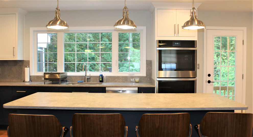 Kitchen pantry - large transitional u-shaped light wood floor kitchen pantry idea in DC Metro with recessed-panel cabinets, blue cabinets, granite countertops, gray backsplash, ceramic backsplash, stainless steel appliances and an island