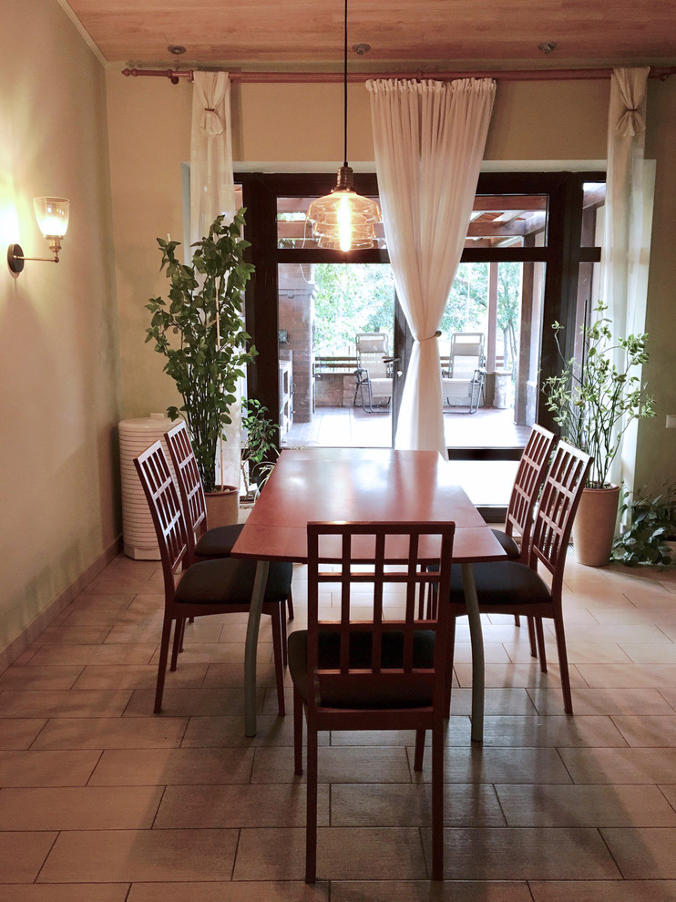 Inspiration pour une salle à manger ouverte sur la cuisine de taille moyenne avec un mur vert, un sol en carrelage de porcelaine et un sol gris.