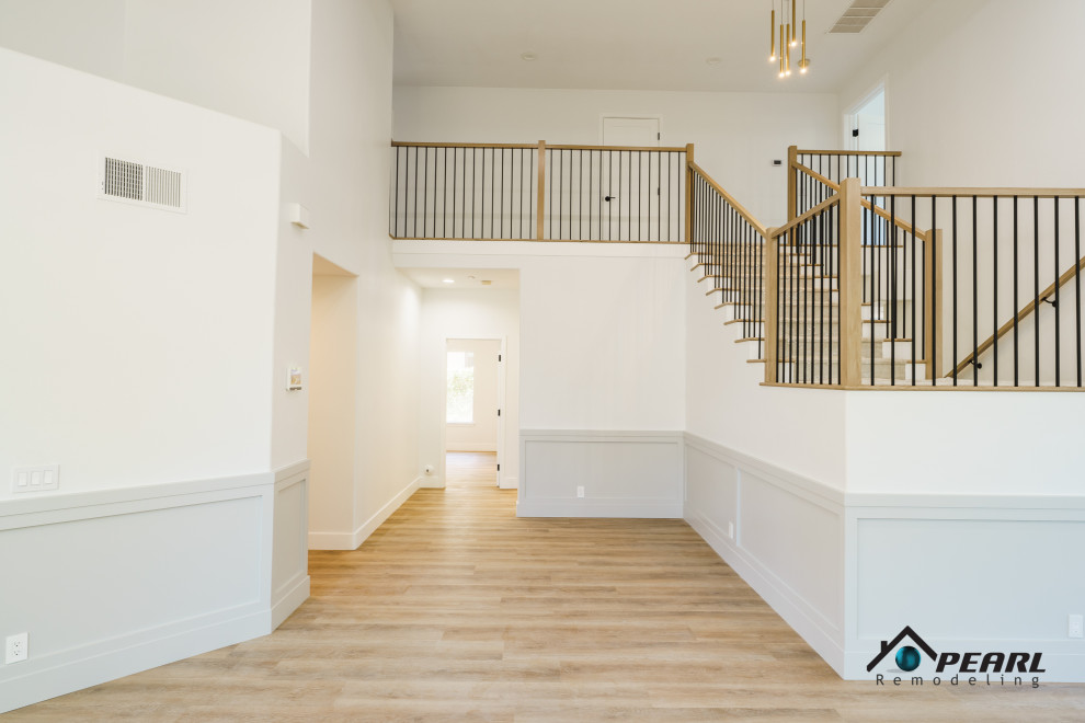 Photo of an expansive modern carpeted l-shaped staircase in Other with wood risers, mixed railing and wood walls.