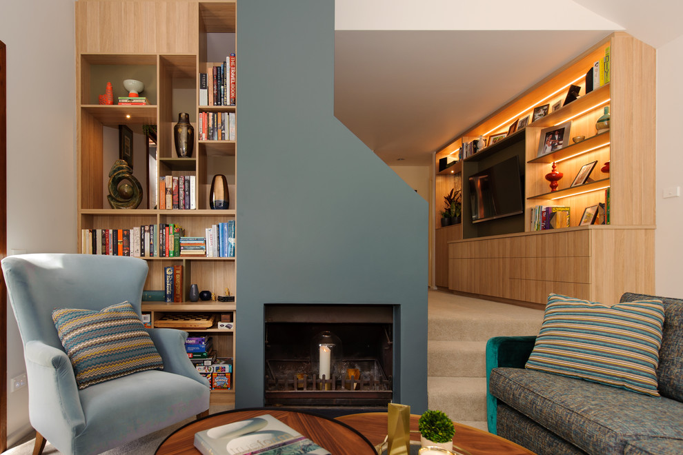 Inspiration for a mid-sized contemporary open concept living room in Sydney with a library, grey walls, carpet, a standard fireplace, a concrete fireplace surround, a built-in media wall and beige floor.