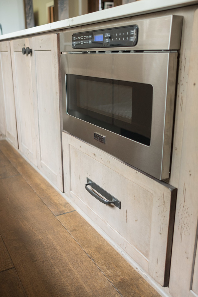 Example of a large transitional galley dark wood floor and brown floor open concept kitchen design with a farmhouse sink, shaker cabinets, quartz countertops, brown backsplash, brick backsplash, stainless steel appliances and an island