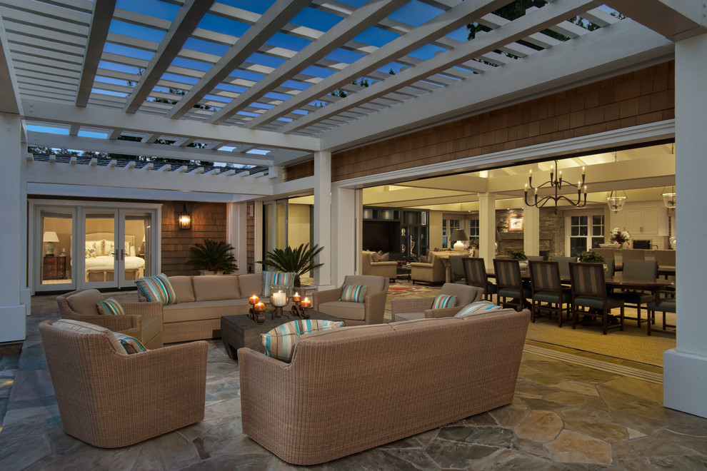 Photo of an expansive traditional backyard patio in San Diego with natural stone pavers and a pergola.