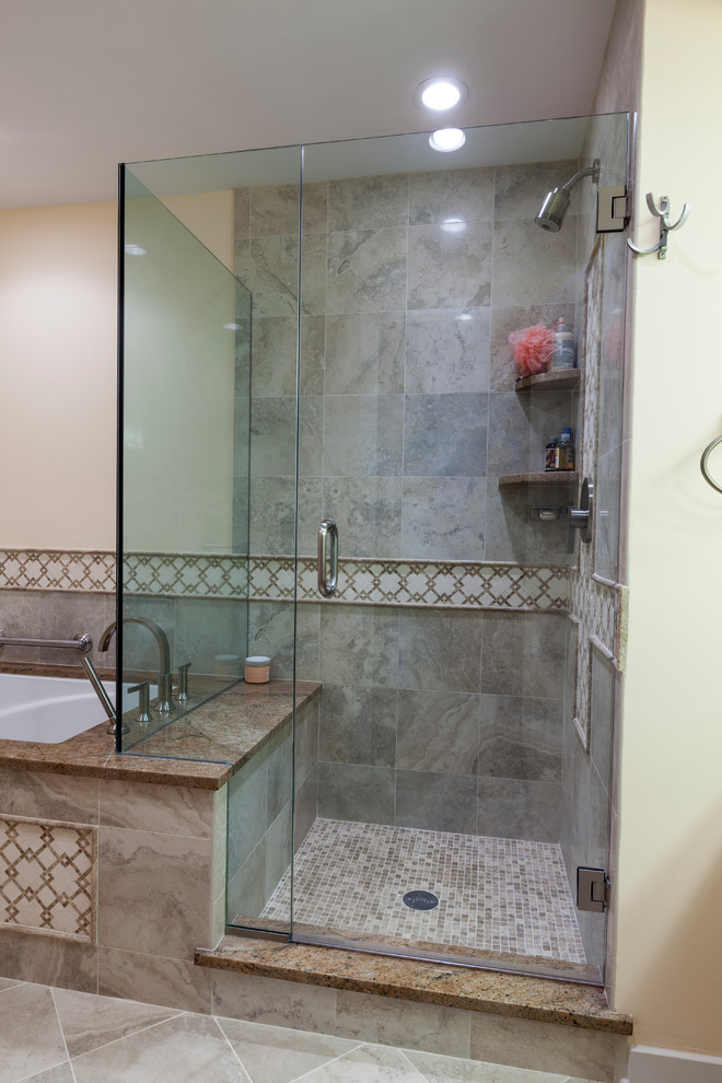 Photo of a mid-sized traditional master bathroom in Bridgeport with an undermount sink, raised-panel cabinets, medium wood cabinets, granite benchtops, an undermount tub, a shower/bathtub combo, a two-piece toilet, beige tile, porcelain tile, beige walls and porcelain floors.