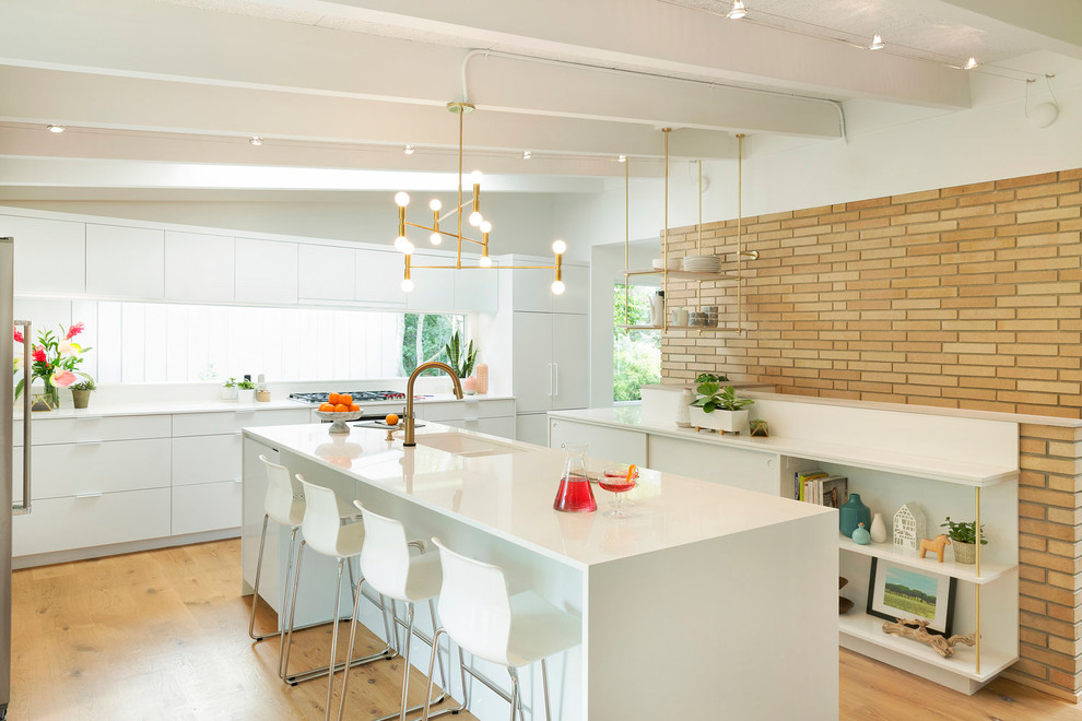 Inspiration for a large midcentury u-shaped open plan kitchen in Minneapolis with flat-panel cabinets, white cabinets, quartz benchtops, window splashback, stainless steel appliances, medium hardwood floors, with island, brown floor and a double-bowl sink.