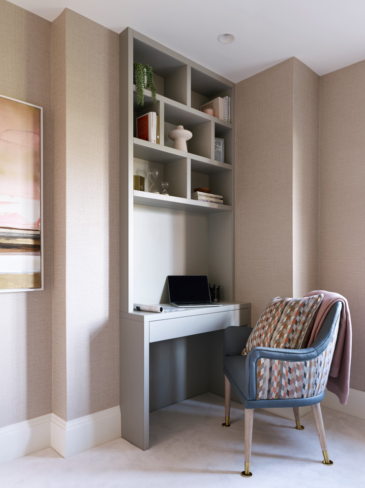 This is an example of a study room in Berkshire with pink walls, carpet, a built-in desk, white floor and wallpaper.