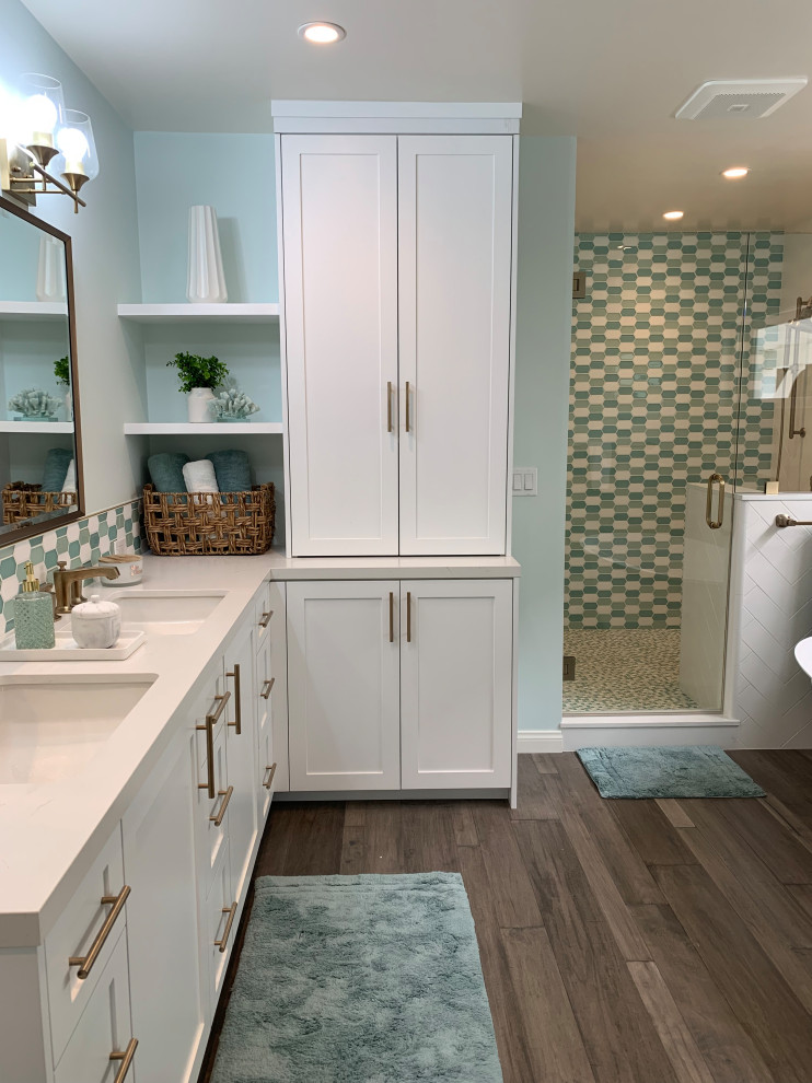 Photo of a medium sized traditional ensuite bathroom in Los Angeles with shaker cabinets, white cabinets, a freestanding bath, a walk-in shower, a one-piece toilet, green tiles, mosaic tiles, green walls, medium hardwood flooring, a built-in sink, quartz worktops, brown floors, a hinged door, a shower bench, double sinks, a built in vanity unit and a vaulted ceiling.