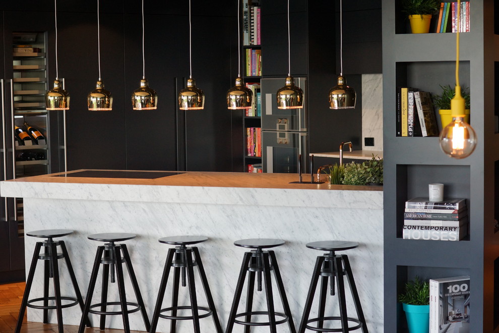 Photo of an industrial kitchen in Sunshine Coast with black cabinets and a peninsula.